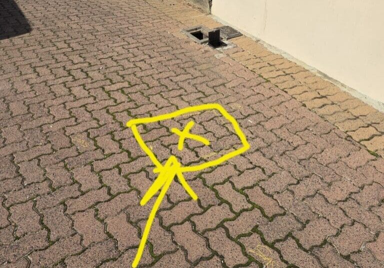 X marking the location of the leak in the driveway